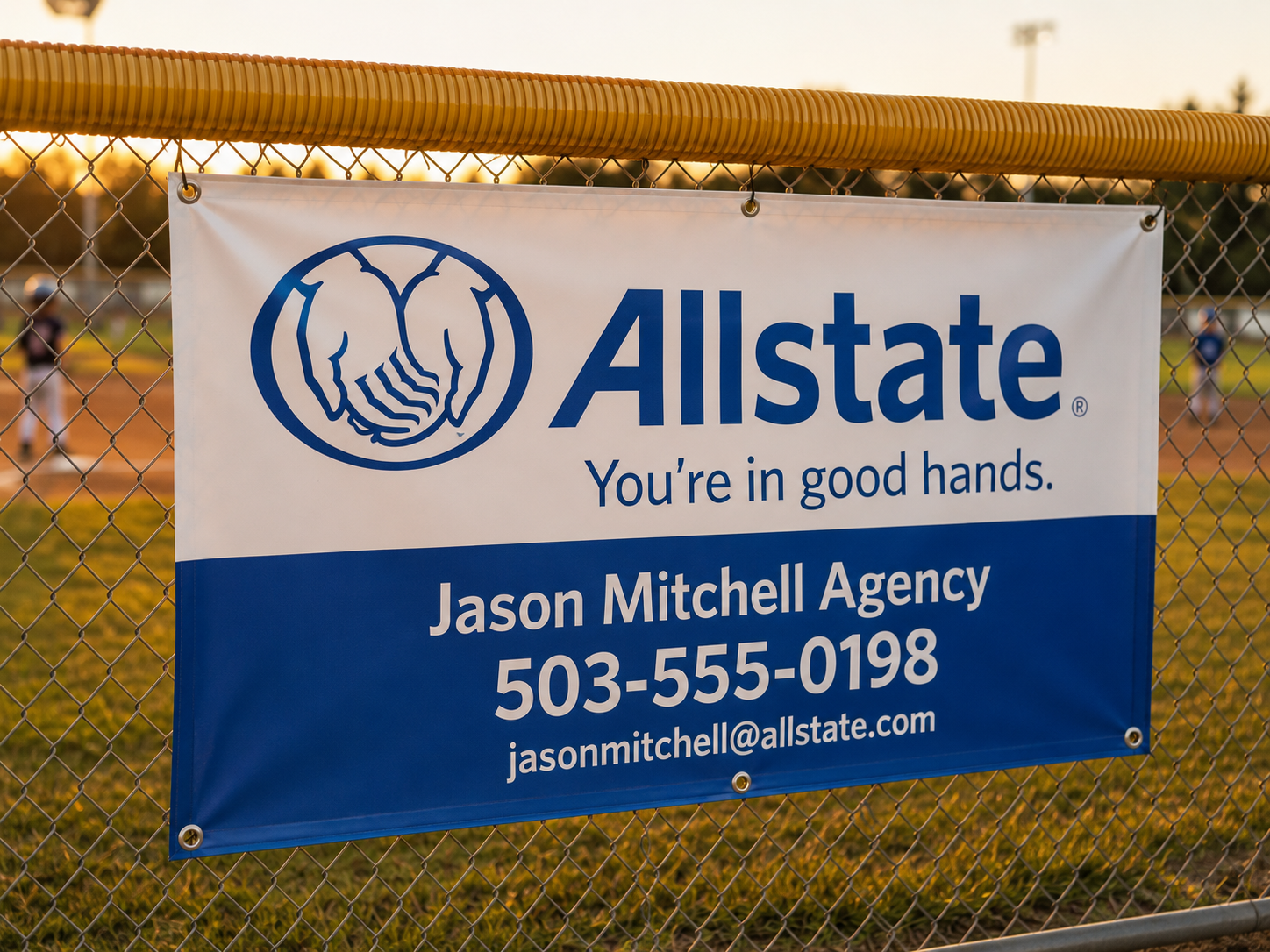 Sponsor banner for a local business mounted on a baseball field fence